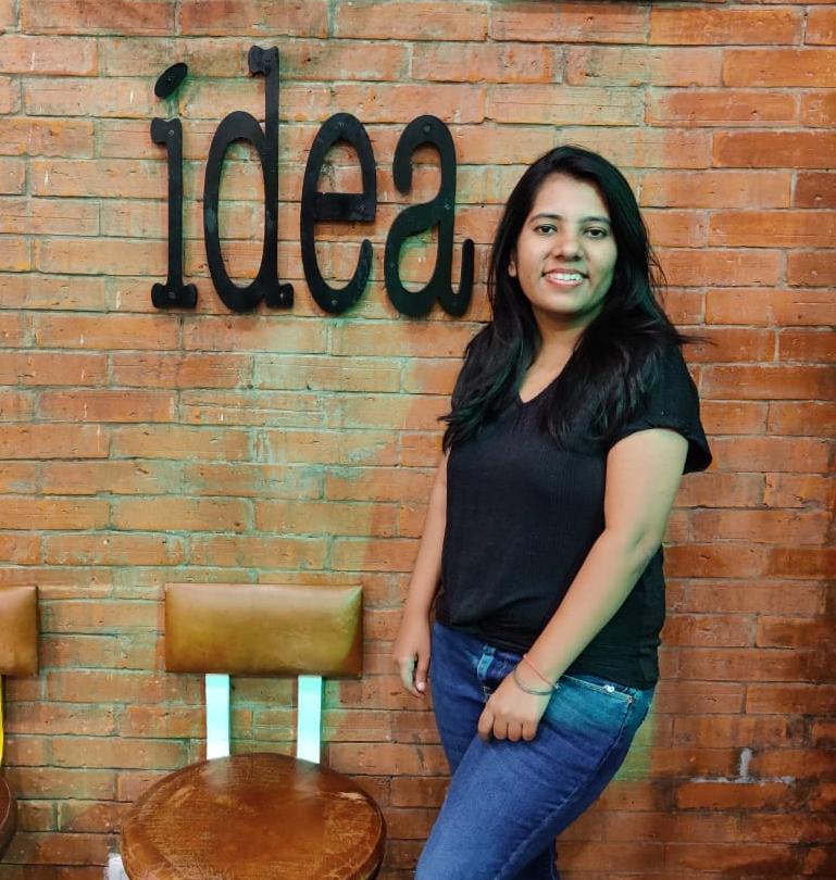 Suchita standing next to an 'idea' wall sign